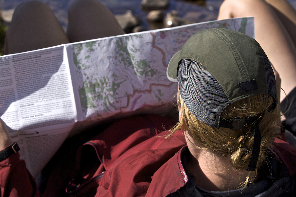 A young woman looks at a trail map on the Teton Crest Trail.