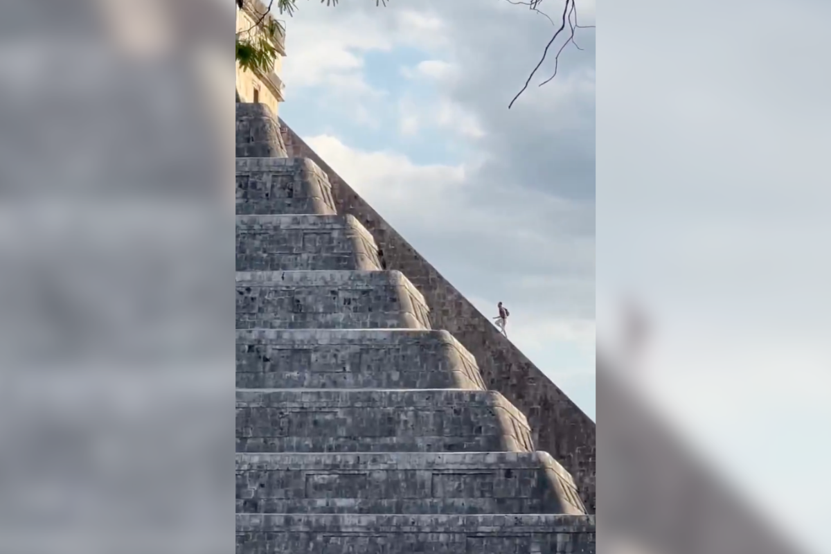 tourist climbs Chichén Itzá